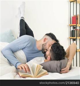 man kissing his boyfriend lying bed with le s leaning wall