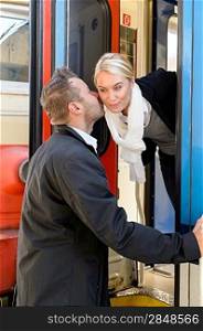 Man kissing woman goodbye on cheek train leaving friends commuter