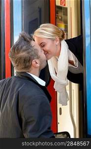 Man kissing woman goodbye train leaving romance couple commuter journey