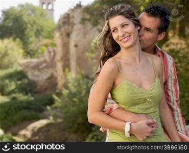 Man kissing woman on neck
