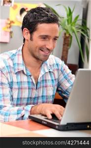 Man laughing in front of computer