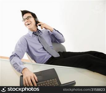 Man laughing on the phone with a computer
