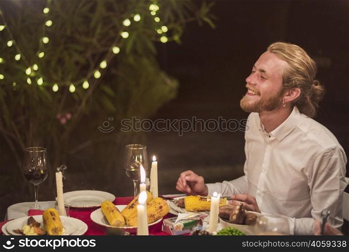 man laughing while sitting festive table