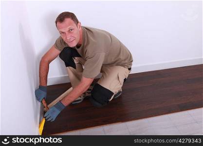 Man laying a wooden floor