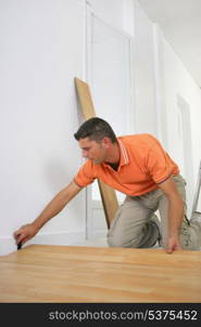 Man laying a wooden floor