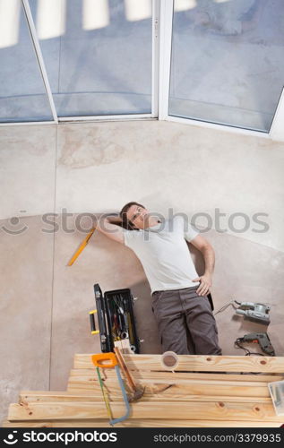 Man laying on ground with home improvement tools