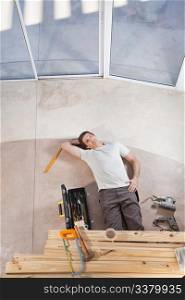 Man laying on ground with home improvement tools