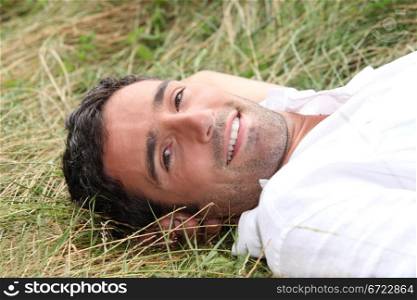 Man laying on his back in field