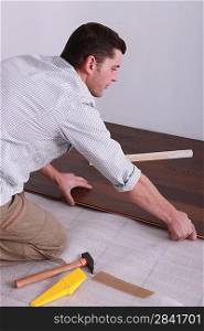 Man laying parquet flooring