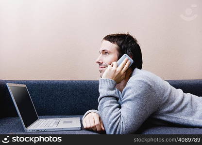 Man laying with laptop on couch
