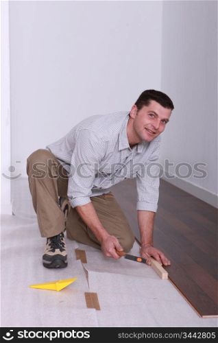 Man laying wooden flooring