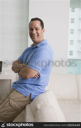 Man leaning against a sofa