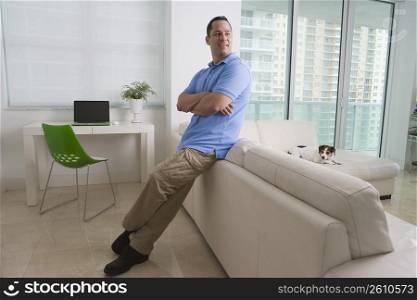 Man leaning against a sofa