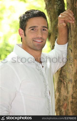 Man leaning against a tree