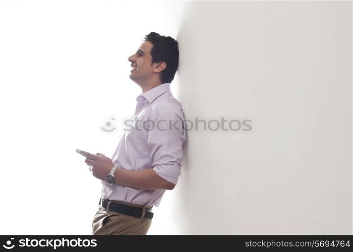 Man leaning against a wall smiling