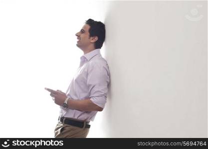 Man leaning against a wall smiling