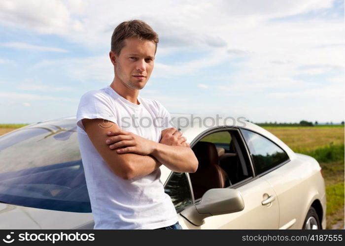 Man leaning on his car; presumably he has a break from driving