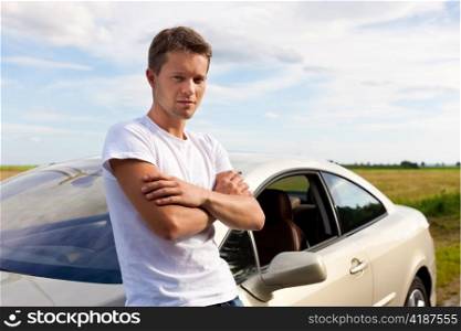 Man leaning on his car; presumably he has a break from driving