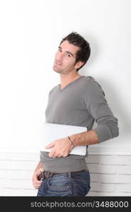 Man leaning on wall with electronic tablet