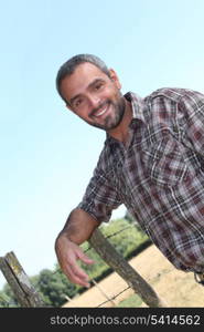 Man leaning on wire fence