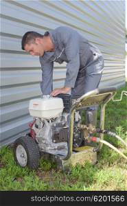 Man leaning over generator