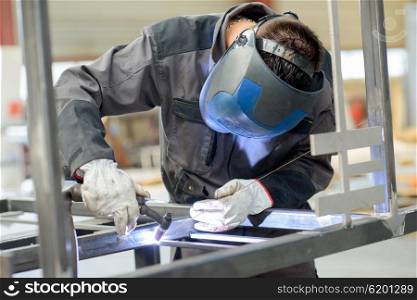 Man leaning over welding