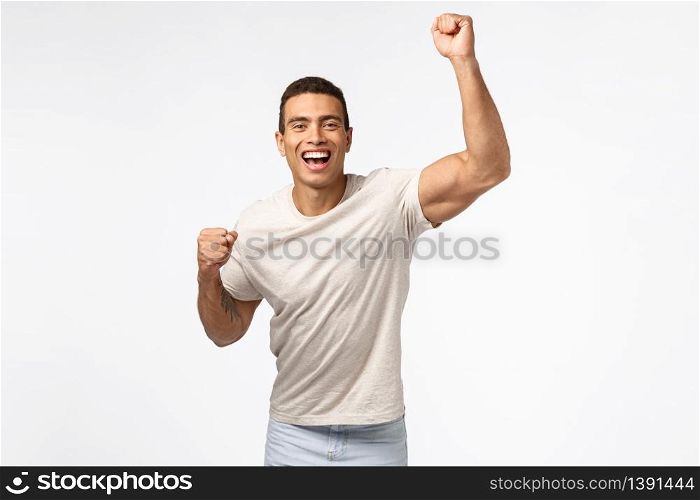 Man lift hand up in hooray motion, cheering for favorite sports team. Handsome young strong guy fist pump and smiling, encourage friend score goal, rooting for someone, placed bet white background.. Man lift hand up in hooray motion, cheering for favorite sports team. Handsome young strong guy fist pump and smiling, encourage friend score goal, rooting for someone, placed bet white background