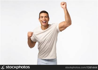 Man lift hand up in hooray motion, cheering for favorite sports team. Handsome young strong guy fist pump and smiling, encourage friend score goal, rooting for someone, placed bet white background.. Man lift hand up in hooray motion, cheering for favorite sports team. Handsome young strong guy fist pump and smiling, encourage friend score goal, rooting for someone, placed bet white background