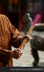man lighting bundle incense temple