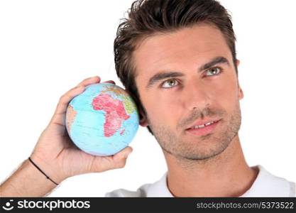 Man listening into a globe