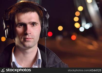 man listening music at city night street