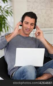 Man listening to his laptop on headphones