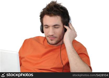 Man listening to his laptop via his headphones