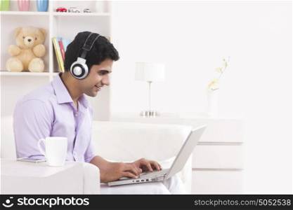 Man listening to music while working on laptop