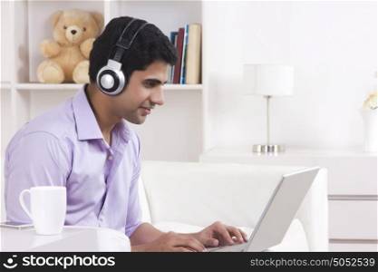 Man listening to music while working on laptop