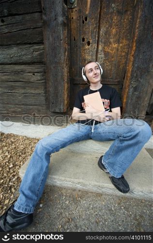Man listening to the music in a park with white headphones