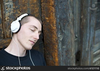 Man listening to the music in a park with white headphones