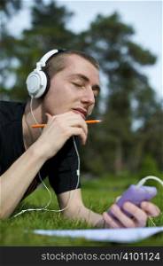 Man listening to the music in a park with white headphones