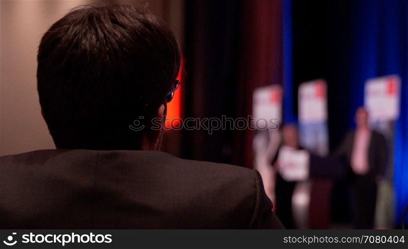 Man listens to lecture at a conference