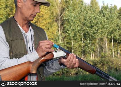 Man loading cartridges into a shotgun