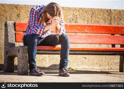 Man long hair alone on bench, lost in thought, is concerned and stressed about events in his life. Unemployment depression concept
