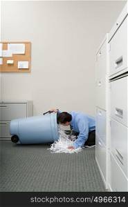 Man looking a shredded paper bin