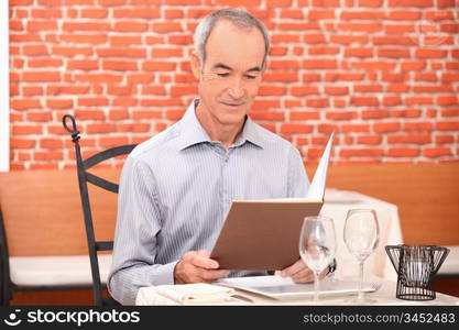 Man looking at a menu in a restaurant