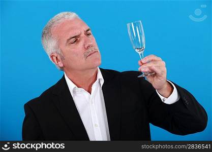Man looking at a wine glass