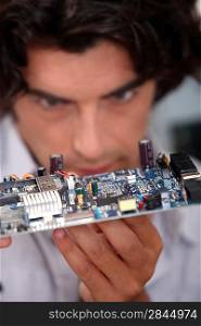 Man looking at an electronic board
