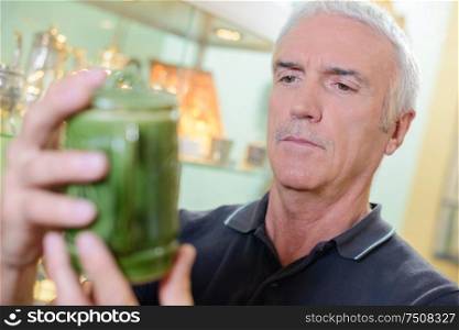 Man looking at antique pot