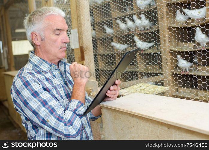Man looking at clipboard in aviary