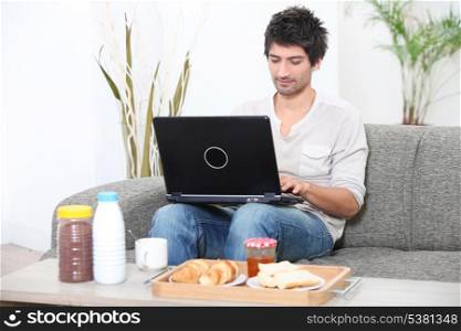 Man looking at his laptop before breakfast