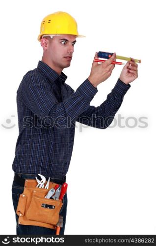 Man looking at his measuring tape surprisingly
