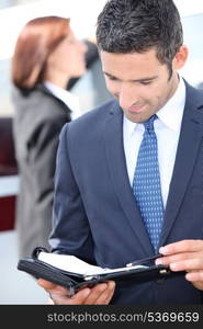 Man looking at his personal organizer